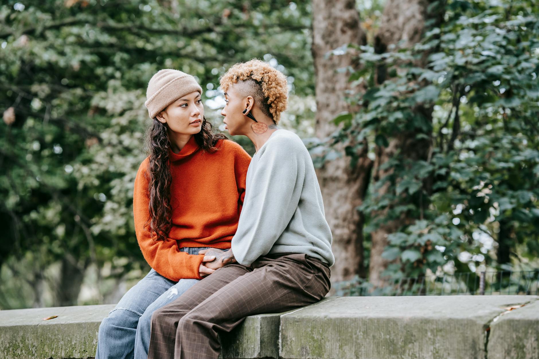 A couple sitting on a sofa engaged in an open, thoughtful conversation about their relationship.