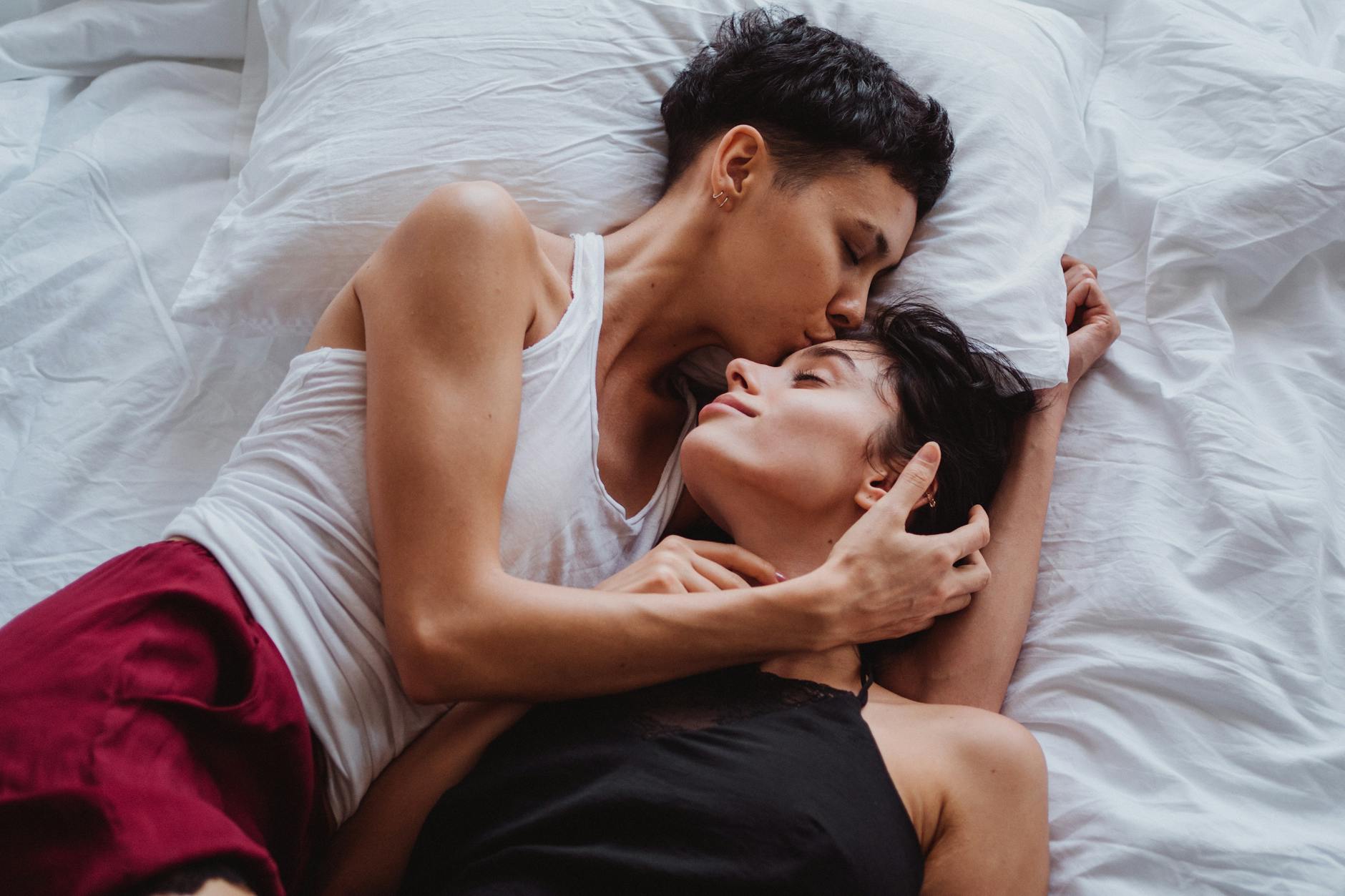 Two people sitting closely together on a sofa, engaged in a meaningful conversation, highlighting intimacy and connection.